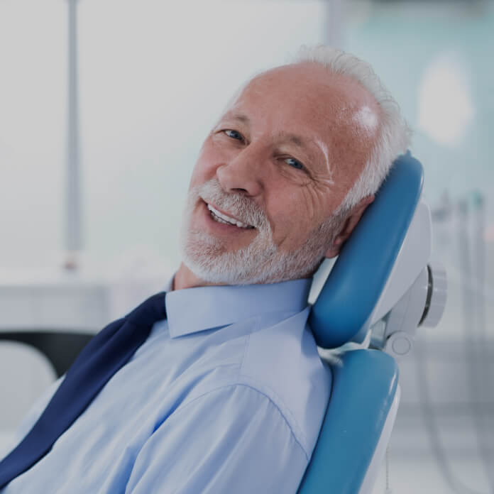 Older man smiling in the dental chair.
